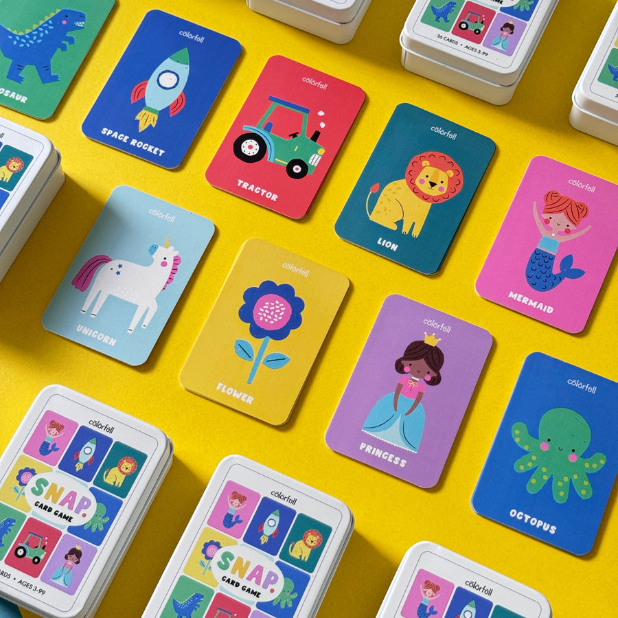 Colorful grid arrangement of illustrated Snap card game cards featuring animals, vehicles, and characters on a yellow surface.