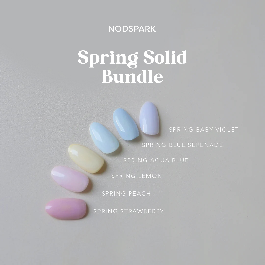 A fan arrangement of pastel-colored nail swatches showcasing the Spring Solids collection against a light grey background.