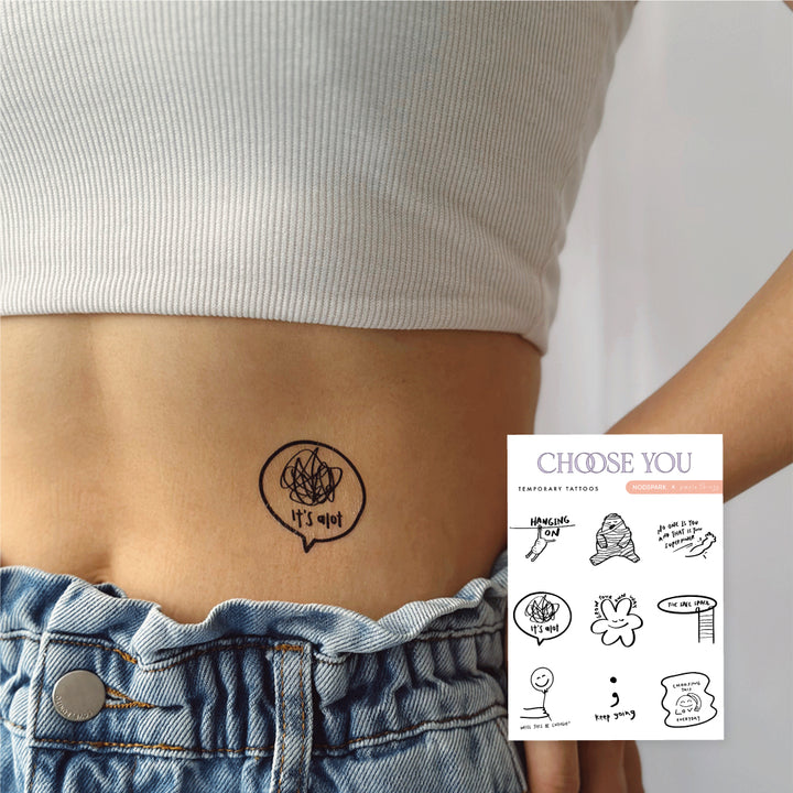 Person wearing a line-art temporary tattoo on their lower abdomen beside an inset image of the full Choose You tattoo sheet.